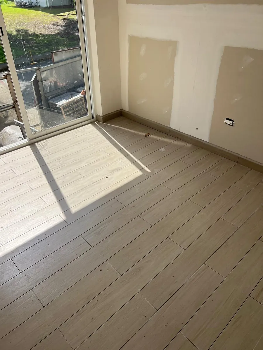 Recámara con piso tipo madera, paredes de yeso y puerta corrediza de vidrio